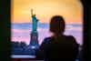 a woman looking at the statue of liberty