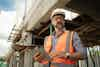 a man in a safety vest and helmet holding a tablet