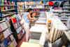 a woman and girl looking at a book in a book store