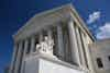 a statue of a man sitting on a bench in front of United States Supreme Court Building