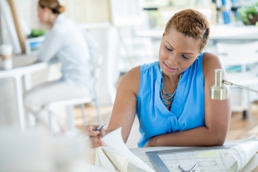  Woman looking over paperwork at a desk. 