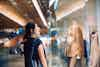 Asian woman looking a dress in a shopping mall. Fall season.