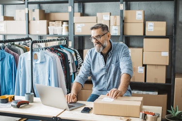  Man working at his small business shipping clothing packages. 